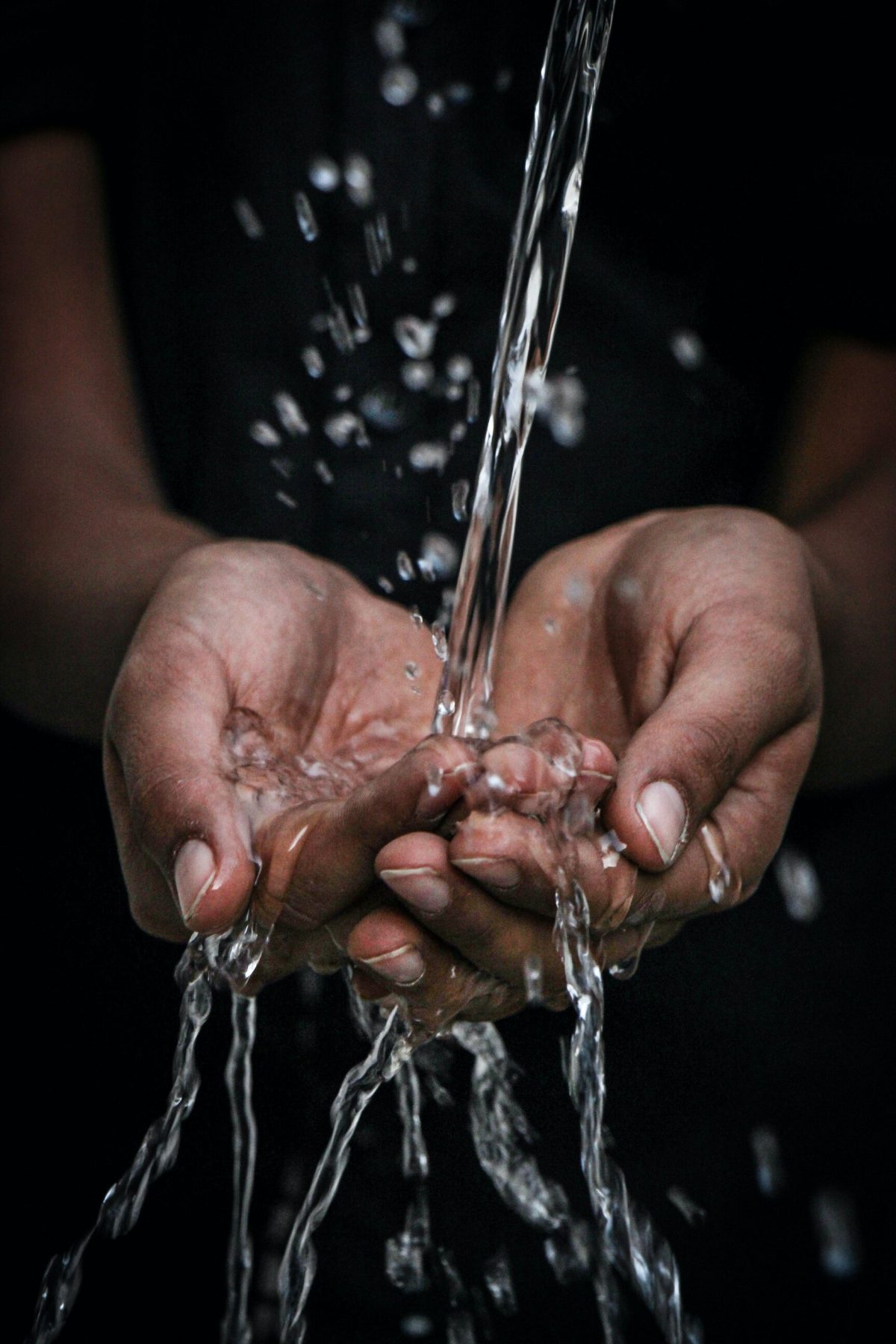 An image of water running into a person's hands (Do I need water filtration for my borehole water?)