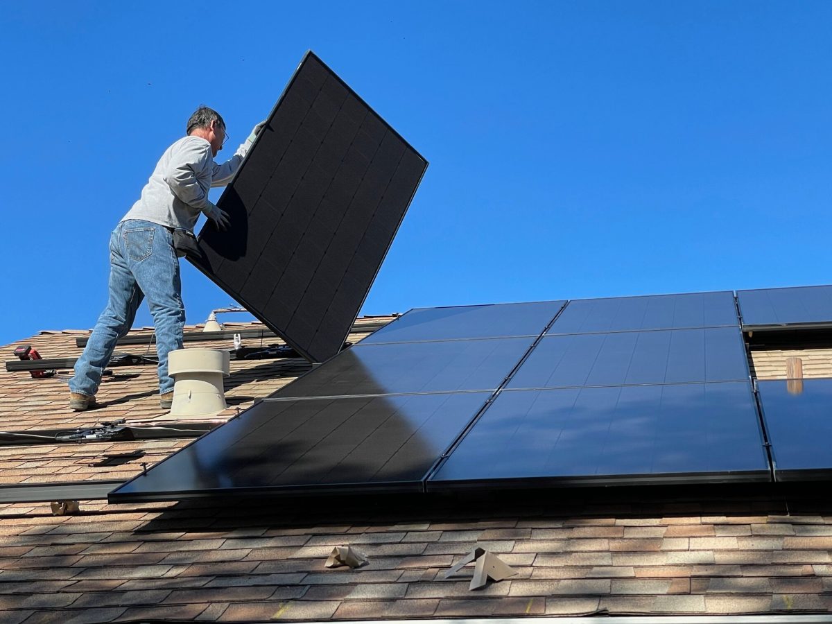 An image of man installing solar panels on a roof