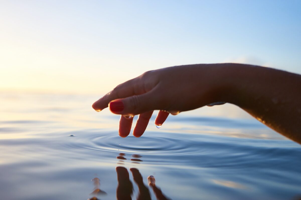 An image of a person's fingers trailing through water