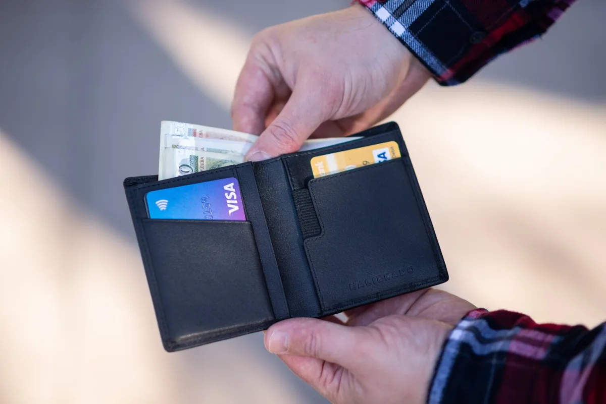 An image of a person holding a wallet with money in it.